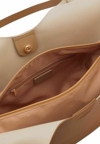 Borsa tote in materiale sintetico beige con un'ampia apertura, hardware dorato e una tasca interna con zip. Texture liscia e design strutturato.