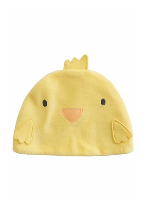 Chapeau en coton jaune en forme de poussin, avec un visage brodé, de petites ailes et une couronne sur le dessus. Texture douce et design arrondi.