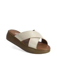 Beige platform sandalen met kruisbanden van glanzend faux leer, een bruine gevoerde voetbed en een gestructureerde rubberen buitenzool voor grip.