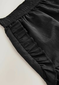 Zwarte shorts met een smock tailleband en gerafelde zijkanten. Gemaakt van lichte stof, met een zachte textuur en een aansluitende pasvorm.