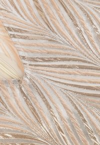 Lichtbeige en gouden stof met golvende textuur en metallic glans; beschikt over afwisselende crèmekleurige en gouden strepen die een gelaagd effect creëren.