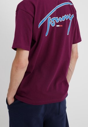 T-shirt di cotone bordeaux con logo 'Tommy' blu sulla schiena, con maniche corte e scollo rotondo. Tessuto morbido e vestibilità rilassata.