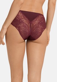 Culotte bordeaux a vita alta con dettagli in pizzo elaborati con un motivo floreale, tessuto morbido e finitura liscia in vita e gambe.