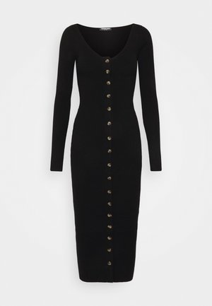 Robe en maille côtelée noire avec manches longues, col en V et une rangée de boutons dorés sur le devant, s'arrêtant sous le genou.