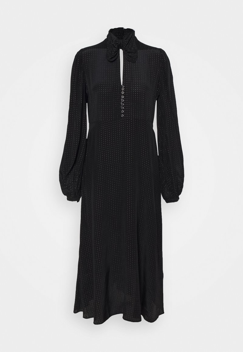 Svart klänning med hög krage och knytdetalj, långa puffärmar, knappslå och prickig textur över hela plagget. Midi-längd silhuett.