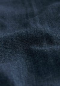 Tissu bleu marine avec une texture lisse et un éclat subtil ; tissé serré avec de légères variations de couleur, indiquant un matériau durable.