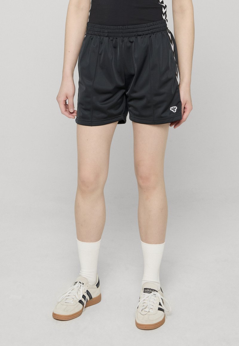 Shorts de sport noirs en tissu lisse et léger avec une ceinture élastique. Présentent un petit logo et des bandes latérales.