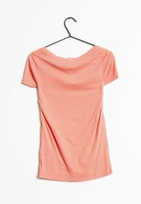 Camiseta de manga corta de color coral, hecha de suave algodón. Presenta un escote redondeado y una silueta ajustada con sutiles frunces en los laterales.