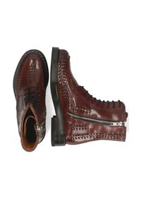 Botas de tobillo de cuero marrón con un diseño cosido, cremallera lateral y punta redonda. Presentan un acabado suave y un tacón bajo y grueso.