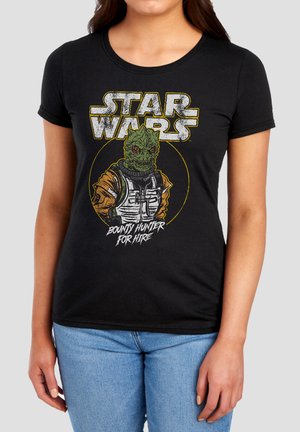 Woman wearing a black Star Wars t-shirt with a green alien bounty hunter illustration and text "Bounty Hunter For Hire" on the front.