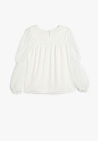 Weiße Bluse mit einem blickdichten Oberteil, das über geraffte Details verfügt, und transparenten, puffartigen Punktenärmeln. Rückenverschluss mit einem kleinen Knopf.