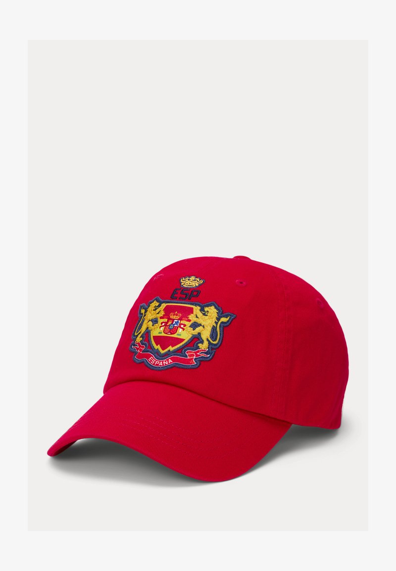 Červená kšiltovka vyrobená z bavlny s vyšitým znakem obsahujícím zlaté lvy, korunu a slovo "ESPANA" na modrém pozadí.