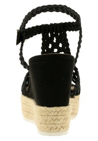 Černý pletený svršek, otevřená zadní část a espadrilová podešev s jute detaily. Texturovaný povrch s polstrovanou stélkou.