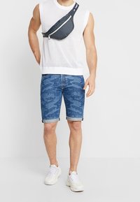 Valkoinen hihaton verkkopaita, siniset camo-farkkushortsit, musta vetoketjullinen vyölaukku ja valkoiset tennarit. Rentoa, urheilullista asua.