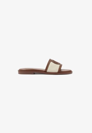 Brown leather slide sandal featuring a beige woven upper, flat sole, and a rounded toe. The design includes a logo accent on the strap.