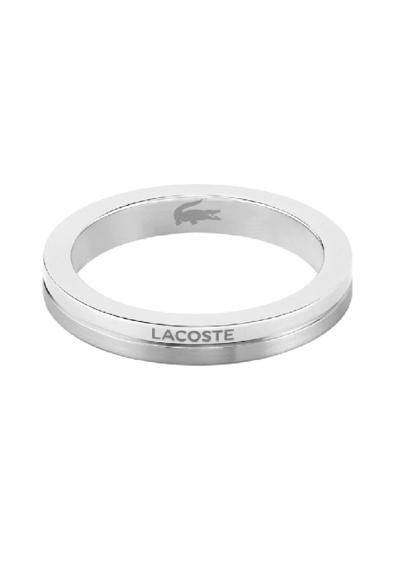 Anello in acciaio inossidabile con finitura liscia e lucida; presenta un logo Lacoste inciso e un design elegante e minimalista.