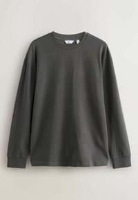 Czarnoszary t-shirt z długim rękawem i okrągłym dekoltem, wykonany z miękkiego materiału bawełnianego. Charakteryzuje się luźnym fasonem i prążkowanymi mankietami.