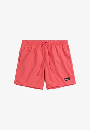 Koralowe szorty kąpielowe z elastycznym paskiem w talii, zapięciem na sznurek, bocznymi kieszeniami oraz czarną naszywką z logo w lewym dolnym rogu.