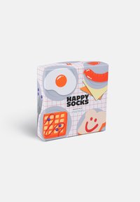 Kleurvolle giftbox met speelse illustraties van ontbijtvoedsel: ei, worst, wafel en toast, met een rasterachtergrond en het merklogo.