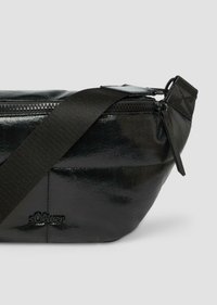 Zwarte neplederen heuptas met een glanzende afwerking, ritsluiting, verstelbare nylon strap en een klein logo op de zijkant.