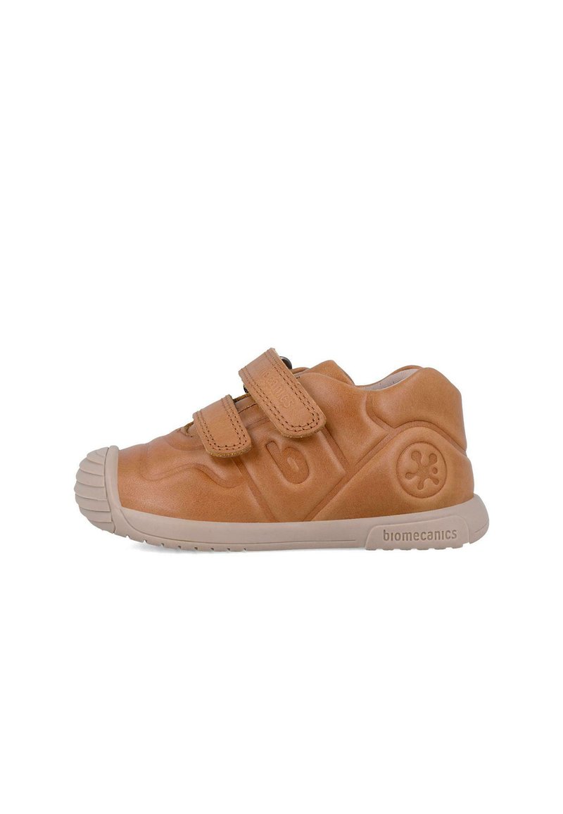 Zapatilla de cuero marrón con dos correas de Velcro, puntera de goma, cuerpo texturizado y suela beige. Presenta el número 6 y el logo de biomecánicas.