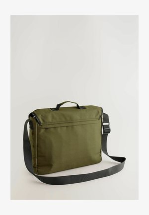 Zielona oliwkowa torba na ramię z górnym uchwytem, regulowanym czarnym paskiem oraz teksturowanym materiałem; ma zamek błyskawiczny i minimalistyczny design.