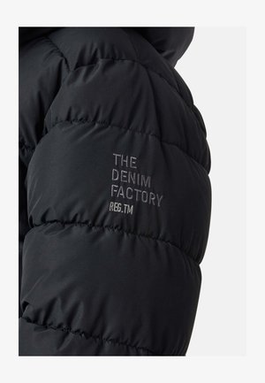 Giacca a vento nera con un design trapuntato. La spalla sinistra presenta la scritta "THE DENIM FACTORY" in ricamo argentato.