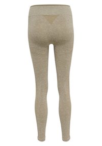 Beżowe legginsy o teksturowanym wykończeniu, z wysokim stanem i trójkątnym detalem na plecach. Gładki, elastyczny materiał, design do pełnej długości.