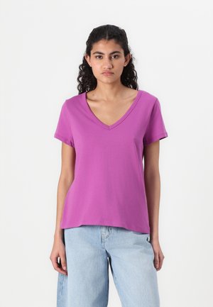 V-hals kortærmet t-shirt i lys lilla bomuld, afslappet pasform med lige kant. Bæres sammen med lyseblå denim jeans.