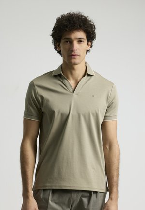 Polo de manga corta color caqui con cuello en V, con un ribete en contraste en el collar y las mangas, que presenta un logotipo sutil en el pecho. Textura suave.