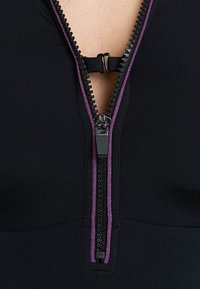 Abito in tessuto nero con una zip centrale e un accento metallico viola, caratterizzato da una texture liscia e un design elegante.