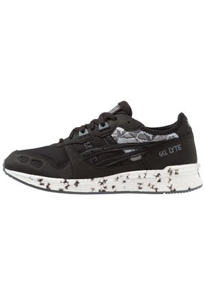 Baskets Asics Gel Lyte noires avec des détails à motifs noirs et blancs et une semelle blanche tachetée.