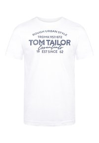 Camiseta de algodón blanca con texto impreso en azul marino que dice "TOM TAILOR Essentials" y detalles gráficos adicionales. Cuello redondo, mangas cortas.