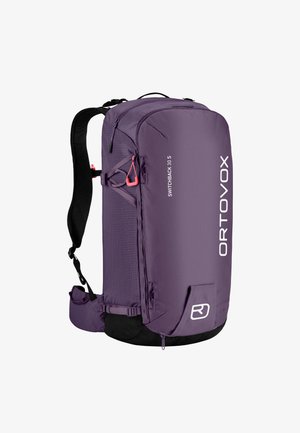 Purple backpack with a smooth texture, zippered compartments, adjustable straps, and a contrasting black base. Features logo and hardware accents.