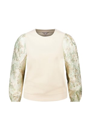 Haut crème à manches longues avec corps uni et manches bouffantes brillantes et texturées présentant un motif floral vert et doré.