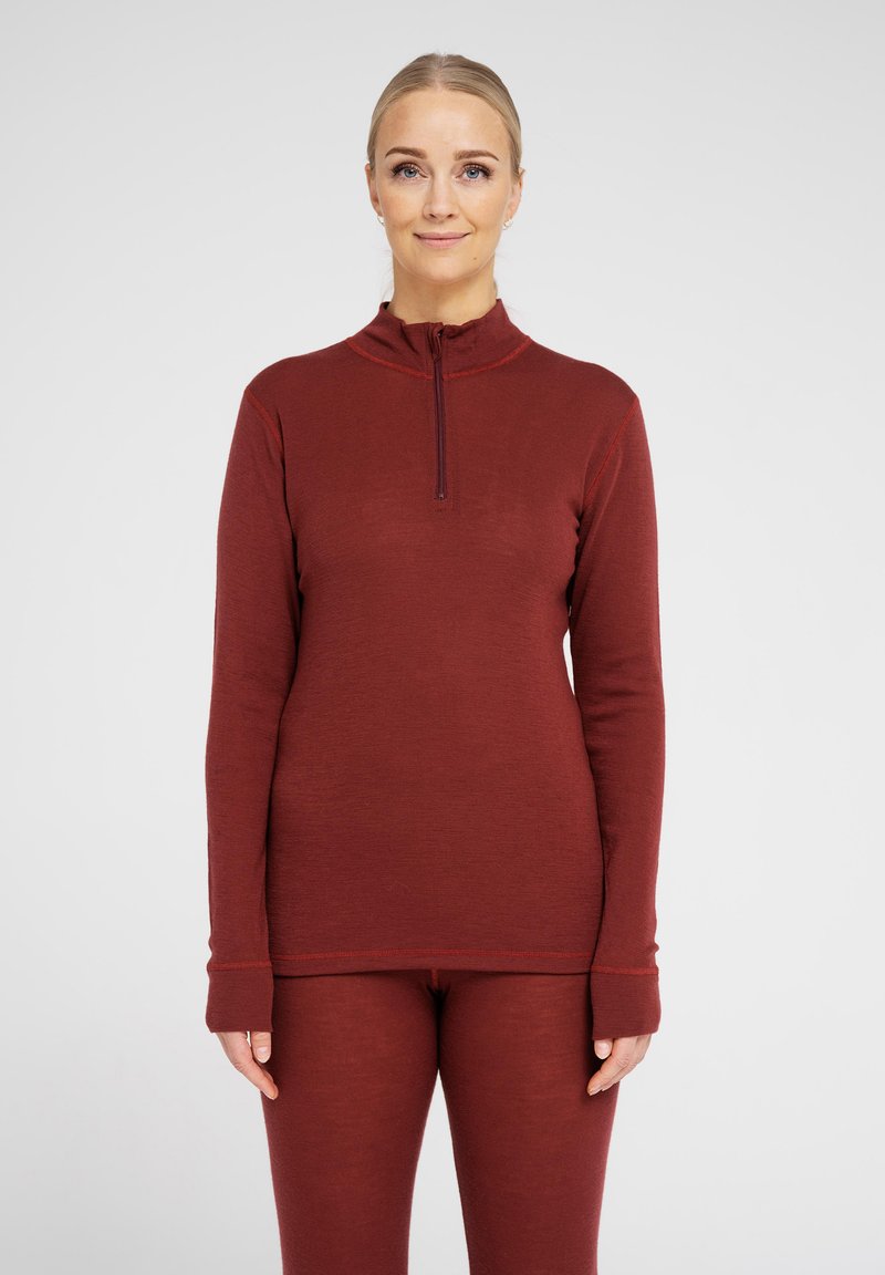 Ribbed burgundy long-sleeve top with a zippered collar, featuring fitted design and extended cuffs, paired with matching fitted pants.