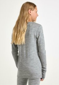 Harmaa pitkähihaisessa paidassa on pehmeä ja joustava materiaali, pyöreä helma sekä saumaton muotoilu. Yhdistettyinä yhteensopivien housujen kanssa.