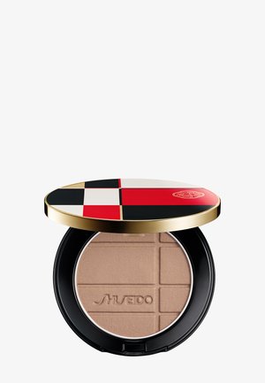Poudre compacte de teinte beige embossée du logo "Shiseido", base noire et couvercle ouvert présentant un motif géométrique rouge, noir et blanc avec une bordure dorée.