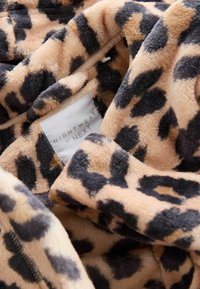 Leopárdmintás bolyhos köntös bézs és barna árnyalatokban, puha tapintással és a "NIGHTWEAR by NEXT" márka látható gondozási címkéjével.