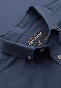 Navy-blaues, knöpfbares Hemd mit Kragen aus gewobenem Stoff. Verfügt über ein Etikett mit "ombre"-Markierung und hellen Knöpfen.