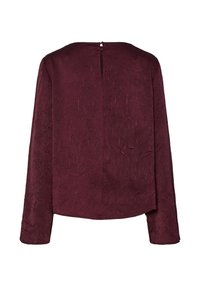 Burgundská blůza s dlouhým rukávem z texturované látky a malým zapínáním na knoflík na horním zadním výstřihu.
