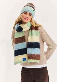 Wielokolorowy dziergany szalik w pasy w kolorze niebieskim, zielonym, brązowym i kremowym, wykonany z miękkiego, puszystego materiału. Zawiera małą niebieską metkę.