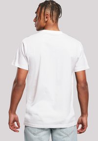White cotton t-shirt with a classic crew neck, short sleeves, and a slightly loose fit, viewed from the back. No visible patterns or accents.