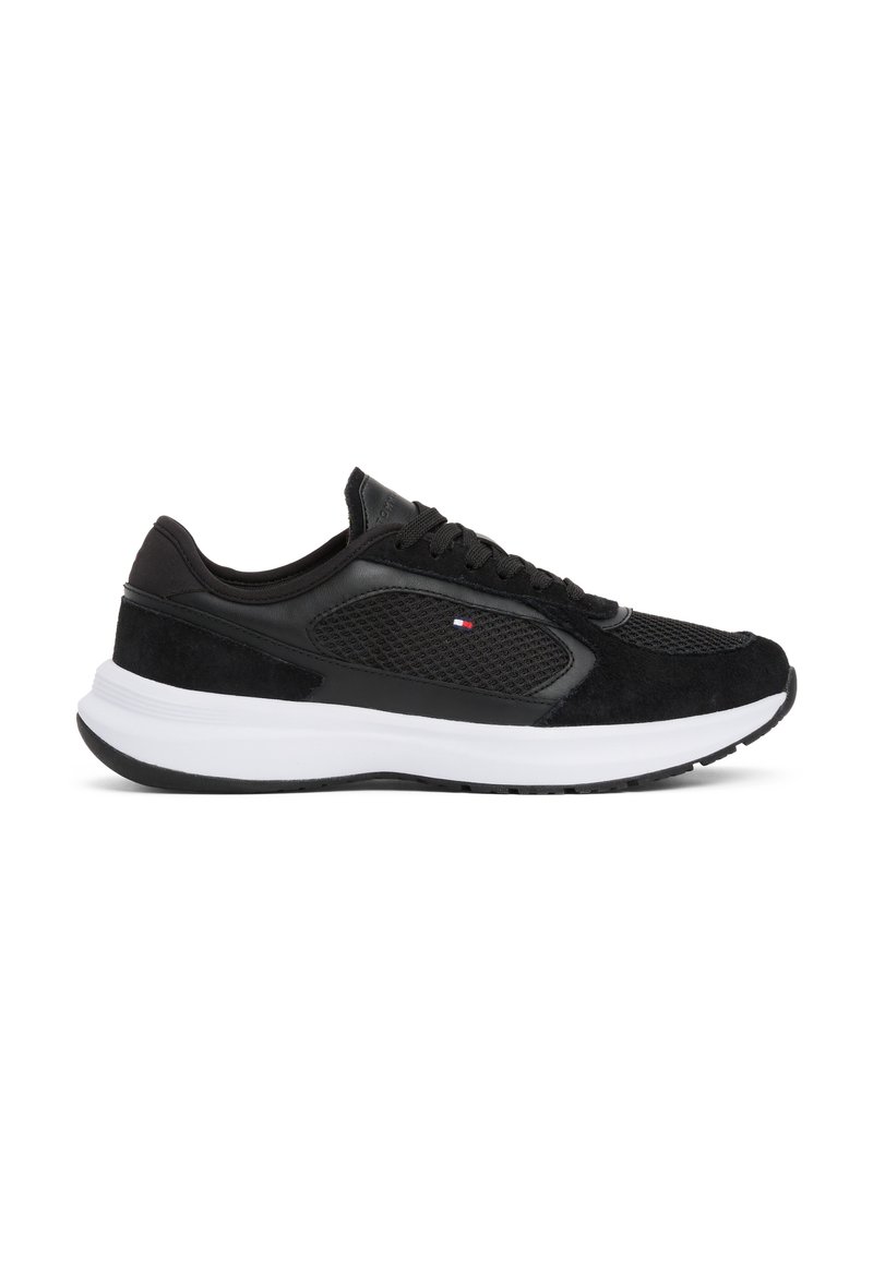 Czarne buty sportowe z połączeniem materiałów zamszowych i siatkowych, z białą podeszwą środkową i teksturowaną gumową podeszwą zewnętrzną. Zapięcie na sznurówki.