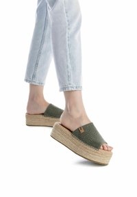 Sandalias de plataforma verde de lona perforada, con una entresuela de yute trenzado y suela de goma, que presentan una textura suave y un mínimo detalle en el hardware.