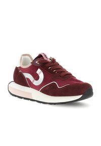 Maroon-nahkasuede ja kangas sneaker, valkoisilla koristeyksityiskohdilla, nauhoilla, pehmustetulla kauluksella ja paksulla valkoisella ja mustalla pohjalla, kallistuneena vasemmalle.
