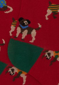Calze rosse con motivi di cani in vari colori, con una sezione del tallone e delle punte verde, realizzate in un morbido tessuto a maglia.