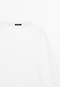 Hvid crewneck T-shirt med lange ærmer og et sort mærke med teksten "Massimo Dutti" på indersiden af kraven.