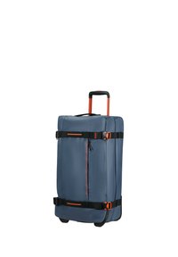Blue fabric suitcase with orange accents, retractable handle, side compression straps, and front zippered pocket. Hard rubber wheels for mobility.