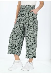 Pantaloni a gamba larga con stampa floreale verde, dotati di elastico in vita e tasche laterali. Il materiale ha una consistenza liscia su uno sfondo nero.